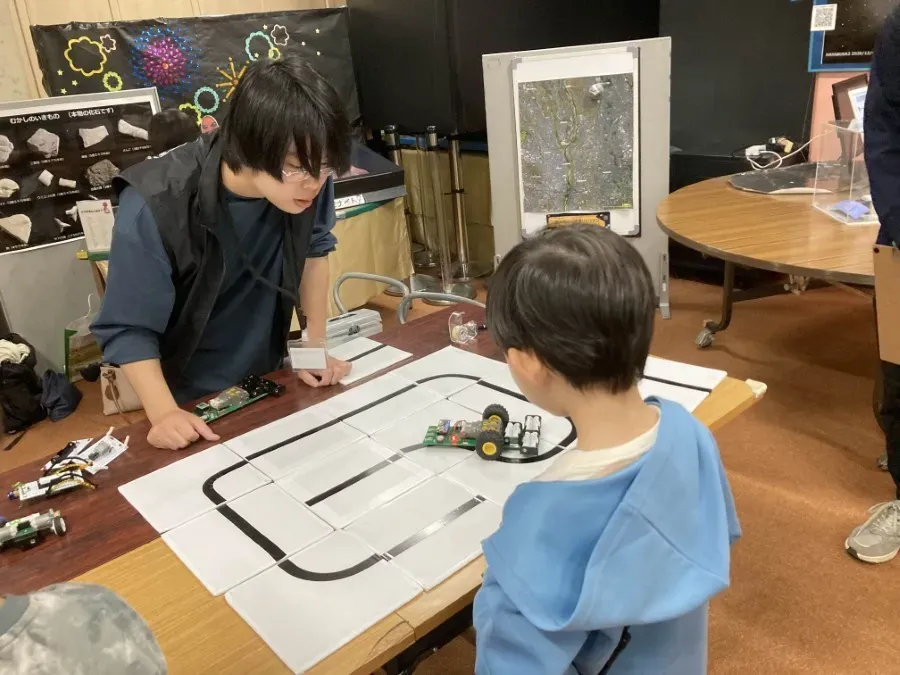 スタッフが子供にロボットの説明をしている様子