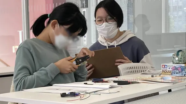 メンバーが生徒に教えている画像